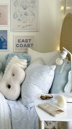 a bed with pillows and pictures on the wall above it, along with other items