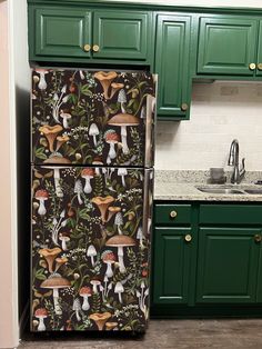 a kitchen with green cabinets and an ornate refrigerator