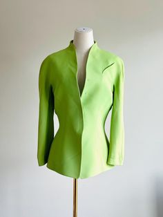 Vintage Thierry Mugler Snap-Front Blazer - Size 40 Very Brat ;) This striking vintage Thierry Mugler blazer in a vibrant green hue embodies the brand's iconic sculptural tailoring. Crafted from a luxurious blend of 53% acetate and 47% viscose, this blazer offers a structured yet soft fit. The unique design features sharp, clean lines with a flattering silhouette, characteristic of Mugler's futuristic aesthetic. The snap-front closure adds a sleek, modern touch to this timeless piece. *Brand: Thi Mugler Blazer, Vintage Thierry Mugler, Futuristic Aesthetic, Thierry Mugler, Womens Blazers, Vibrant Green, Clean Lines, Timeless Pieces, Blazer Suit