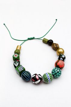 Brighten up your day with this wooden green goddess necklace. It's chunky, funky and colorful so it's a real statement piece. This one is a combination of different shades of green, mustard yellow, white and gold plus heaps of different-sized polka dots, stripes and floral motives. The size of the beads goes from 13 mm to 30 mm. The cord is waxed polyester. It's flexible yet durable. The sliding knot will enable you to adjust the length in no time. The maximum length is 70 cm or 27 inches. Pleas Green Wooden Beaded Necklaces, Unique Green Wooden Beaded Necklaces, Unique Green Necklaces With Wooden Beads, Artsy Green Necklaces For Jewelry Making, Green Wooden Beads Jewelry Gift, Green Wooden Beads Jewelry For Gift, Adjustable Green Beaded Necklace With Wooden Beads, Bold Handmade Green Jewelry, Unique Green Necklace With Large Beads