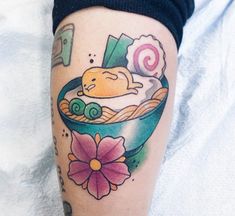 a woman's leg with a tattoo on it that has an image of a bowl of food in it