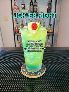 there is a green drink with a cherry on the rim in front of a bar