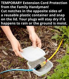 a person holding a plastic container filled with water and hoses next to some plants