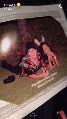 two people are laying on the ground in front of a polaroid with an image of them