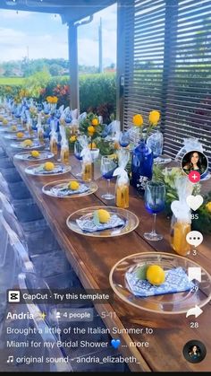 a long table with plates and glasses on it, surrounded by lemons in vases