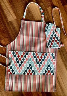 two aprons sitting on top of a wooden floor