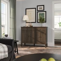 a living room scene with focus on the sideboard and couches in the background