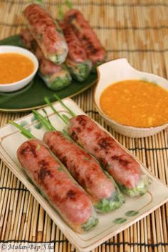 some food is sitting on a table with bowls and sauces