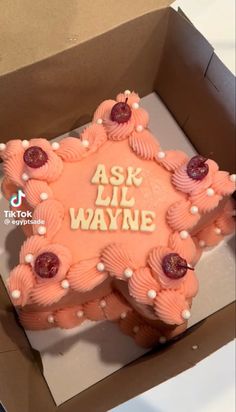 a pink cake in a box with the words ask lil wayne on it's side