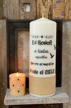 a white candle sitting on top of a wooden shelf