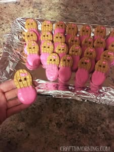 a person is holding up some cookies with pink icing on them in the shape of hearts