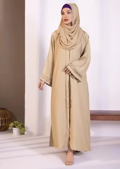 Abaya & hijab set for Women. Description : Abaya : Full length abaya in soft, drapey fabric. Button through front opening. V neckline. Full sleeves with diamanté and pleats detail. Material : Nidha Color: Beige Country : Made in Pakistan Long Thobe With Modesty Panel For Eid, Solid Color Abaya With Modesty Panel For Eid, Solid Long Thobe For Eid, Modest Abaya With Modesty Panel For Eid, Long Thobe For Eid, Eid Abaya With Modesty Panel In Solid Color, Long Abaya With Modesty Panel For Eid, Eid Abaya With Modesty Panel, Modest Long Abaya For Eid