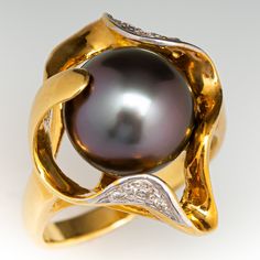 This captivating ring features an organic design and is centered with one (1), post set, cultured Tahitian pearl. The pearl is bordered with eight (8), bead set, round brilliant cut diamonds. The ring measures 22.7mm at the top, rises 12.8mm above the finger, tapering to 2.6mm wide and 0.9mm thick at the base of the shank. This ring is currently a size 7.75. Tahitian Pearls Jewelry, Diamond Cocktail Ring, Organic Rings, Diamond Cocktail Rings, Bead Set, Tahitian Pearls, Organic Design, Pearl Diamond, The Pearl