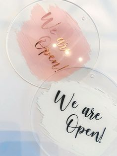 two acrylic signs that say we are open