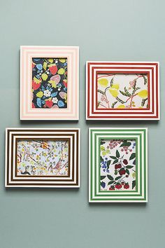 four framed pictures hanging on the wall with different patterns and colors, each featuring flowers