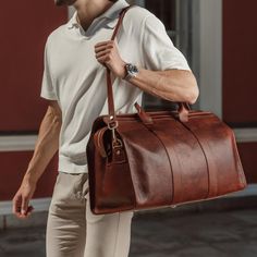 We designed the leather Weekender bag to be practical, spacious, and timelessly elegant—a men's holdall that fits everything you need. Handcrafted in Northern Italy by experienced craftsmen in family-owned studios, the Weekender is made from full-grain vegetable-tanned cow leather of exquisite quality. Smooth yet robust top leather handles make it easy to carry and there's an adjustable leather shoulder strap too which you can easily remove when necessary. The spacious main compartment of this o Timeless Leather Duffle Bag For Everyday Use, Classic Textured Leather Rectangular Weekender Bag, Classic Rectangular Textured Leather Weekender Bag, Leather Satchel Weekender Bag, Timeless Leather Duffle Bag For Business, Luxury Rectangular Oiled Leather Bag, Formal Leather Weekender Bag, Luxury Oiled Leather Everyday Bag, Formal Soft Leather Weekender Bag