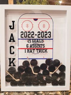 an ice hockey goalie shadow box with sticks in it and the words jack written on it