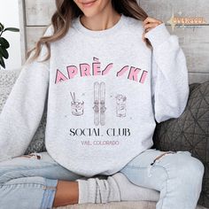 "Step into the après ski scene in style with our retro-inspired crewneck sweatshirt. Featuring bold, retro lettering that spells out \"Après Ski Social Club\" across the front with hand-drawn imagery of skis and classic beverages. This sweatshirt exudes the classic charm of designer ski sweaters and is perfect for your next trip to Vail! Elevate your post-ski relaxation with a touch of vintage flair and stay cozy in this must-have après ski essential. ----- How To Order ----- 1.) Please review all photos and size chart. 2.) Choose your sweatshirt size and color. 3.) Click add to cart. You can go back to add more shirts at any time! 4.) Click \"Proceed to check out.\" 5.) When you check out, you can add a note to seller for any requests you may have! ----- About Product ----- - Relaxed fit, Casual Crew Neck Sweater For Ski Season, Retro Crew Neck Sweatshirt For Winter, Casual Crew Neck Sweatshirt For Ski Season, Crew Neck Sweatshirt For Winter Sports, Casual Crew Neck Sweatshirt For Snowboarding, Sporty Winter Sweater With Lettering, Retro Graphic Print Sweatshirt For Winter, Ski Lodge Party, Bachelorette Sweatshirts