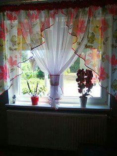 a window with curtains and flowers in it