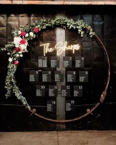 a wedding seating chart with flowers and greenery in the shape of a cross on a wall