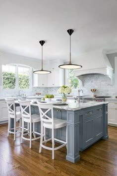 a kitchen with white cabinets and blue island