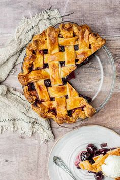 a piece of pie on a plate with a scoop of ice cream next to it