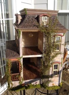 a doll house is shown in front of a window