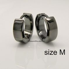 Men's medium hoop earrings in size M. These huggie hoops are 12mm in diameter and 3mm wide. The earrings have a polished shiny finish and are plated in black gold and have a charcoal grey color. We make various sizes in this style https://www.etsy.com/listing/60279626/sterling-silver-earrings-black-gold?ref=related-3 SPECIFICATION Base metal: Recyclable fine 925 Sterling Silver Outer layer: Black gold, polished finish, charcoal grey Width: 3mm Inner Diameter : 9mm, medium Outer Diameter: 12mm Ea Minimalist Black Small Hoop Huggie Earrings, Small Black Classic Hoop Earrings, Classic Small Black Hoop Earrings, Classic Small Hoop Earrings In Black, Modern Black Huggie Hoop Earrings, Black Hypoallergenic Huggie Earrings, Small Black Hoop Earrings, Men's Earrings, Mens Earrings Hoop