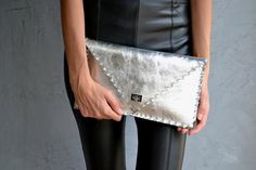 Silver Symmetria Clutch.The perfect bag for all occasions!Ideal for cocktail and parties or for business meetings depending the size you choose.You can use it as a chic briefcase for your work or as a modern large clutch for a night out.This adorable clutch is handmade out of a genuine, lux Italian silver cow leather.-Small size fits all your essentials, wallet, keys, mobile, cosmetics etc.-Large size fits a 15" laptop, ipad, portofolio etc and it's perfect as a file folder or as modern a laptop Metallic Clutch Bag, Leather Envelope Clutch, Metallic Clutch, Leather Envelope, Large Clutch, Leather Clutch Bag, Bag Silver, Shoulder Chain, Envelope Clutch