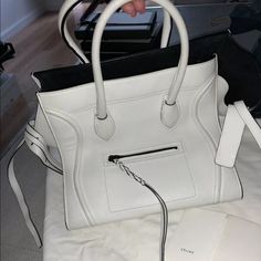 Celine Phantom In A Bright White Buttery-Soft Calfskin Leather. The Phantom Is Accented With A Braided Tassel And Contrasting Black Trim And Black Suede Lining. This Bag Is A Rare Colorway And Took Me Months To Track Down! Purchased From Saks. There Are A Few Scuffs On The Back Side Of The Bag Along With Light Color Transfer To The Handles. Some Creasing. I Believe A Good Leather Spa Can Have This Beauty Looking Brand New. 100% Authentic. Comes With Original Dustbag And Celine Card. White Classic Calf Leather Bag, White Calf Leather Bag For Formal Occasions, Classic White Calf Leather Bag, Designer White Calf Leather Bag, Everyday Luxury White Bags With Leather Lining, Designer White Calf Leather Shoulder Bag, Designer White Soft Leather Bag, White Top Handle Bag With Leather Lining, Luxury White Bags With Leather Lining