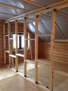 an unfinished room with wooden walls and shelves