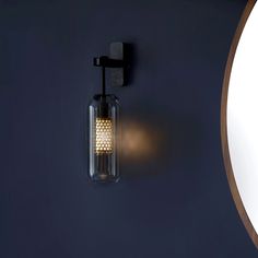 a wall mounted light on the side of a blue wall next to a round window