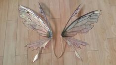 two metal wings laying on top of a wooden floor