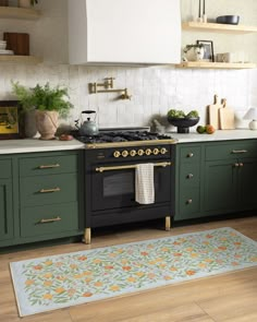 a kitchen with green cabinets and an area rug on the floor in front of the stove