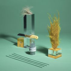 two different types of tools are shown in this still - life photo, one is made out of glass and the other has a feather on it's stand