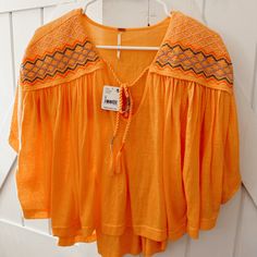 New With Tags Comfy And Flowy Blouse With Tassel Detailing Embroidered Orange V-neck Tops, Orange Embroidered V-neck Top, Long Sleeve Orange Top With Floral Embroidery, Orange Floral Embroidered Long Sleeve Top, Summer Embroidered Orange Blouse, Orange Embroidered Summer Blouse, Spring Embroidered Orange Blouse, Summer Orange Embroidered Blouse, Orange Embroidered Tops For Summer