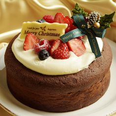 a chocolate cake with white frosting and fruit on top