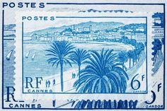 an old postage stamp with palm trees in the foreground and a beach on the far side