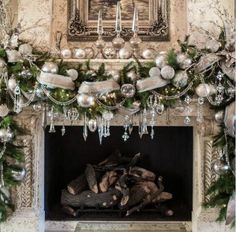 a fireplace decorated for christmas with ornaments and garland