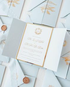 wedding stationery in pale blue and gold with envelopes, wax seals and coins