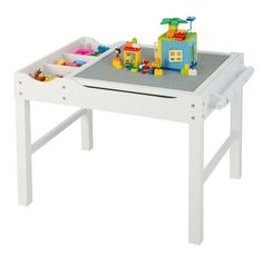 a white table with legos on it and toys in the tray at the top