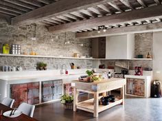 a kitchen with stone walls and exposed beams