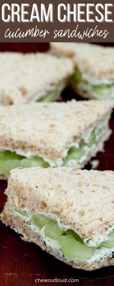 four sandwiches with cream cheese and cucumber sandwiches cut in half on a wooden table