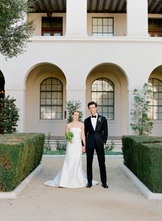 a bride and groom standing in front of a building