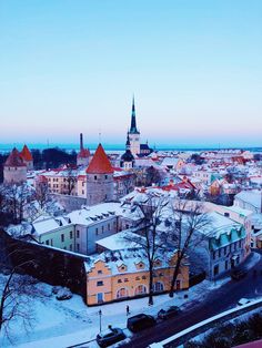 the city is covered in snow and surrounded by tall buildings with spires on top