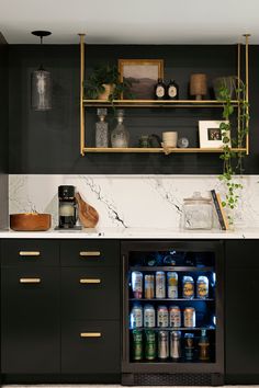 a black and white kitchen with an open refrigerator in the center, surrounded by plants