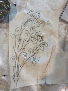 a piece of cloth with flowers drawn on it next to a compass and other items