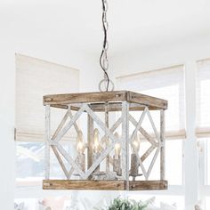 a chandelier hanging from the ceiling in a room with white walls and windows