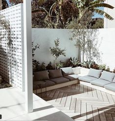 an outdoor living area with couches and plants