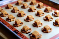 small pretzels are arranged on a baking sheet with caramel in the middle